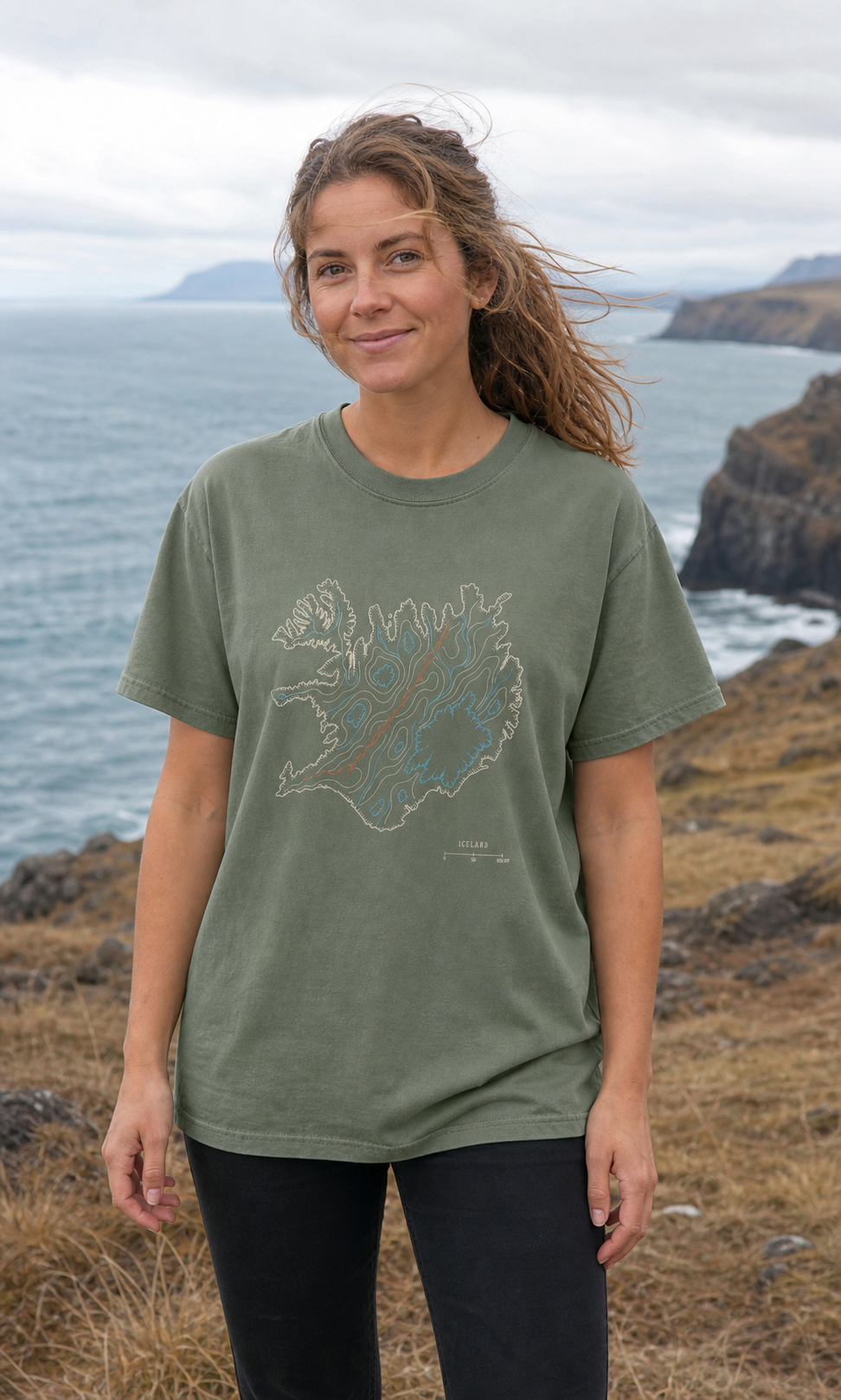 Woman wearing the Moss Iceland Rifted Relief T-Shirt at an Icelandic coastal overlook
