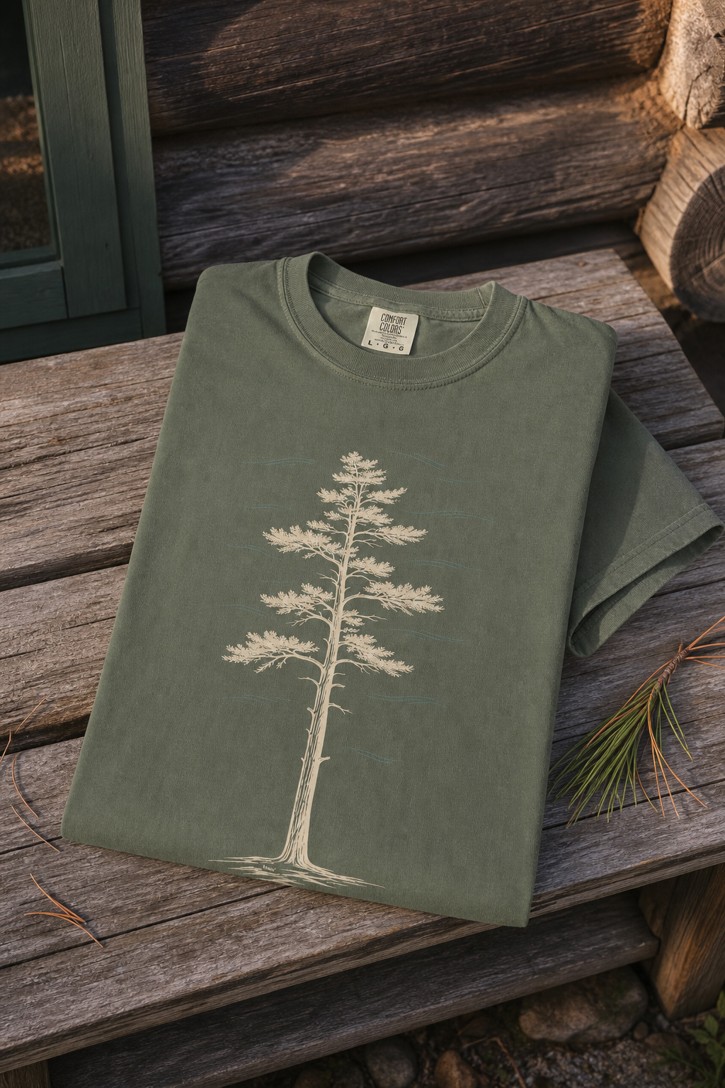 Moss White Pine Stand Comfort Colors T-Shirt folded outside a Northwoods cabin