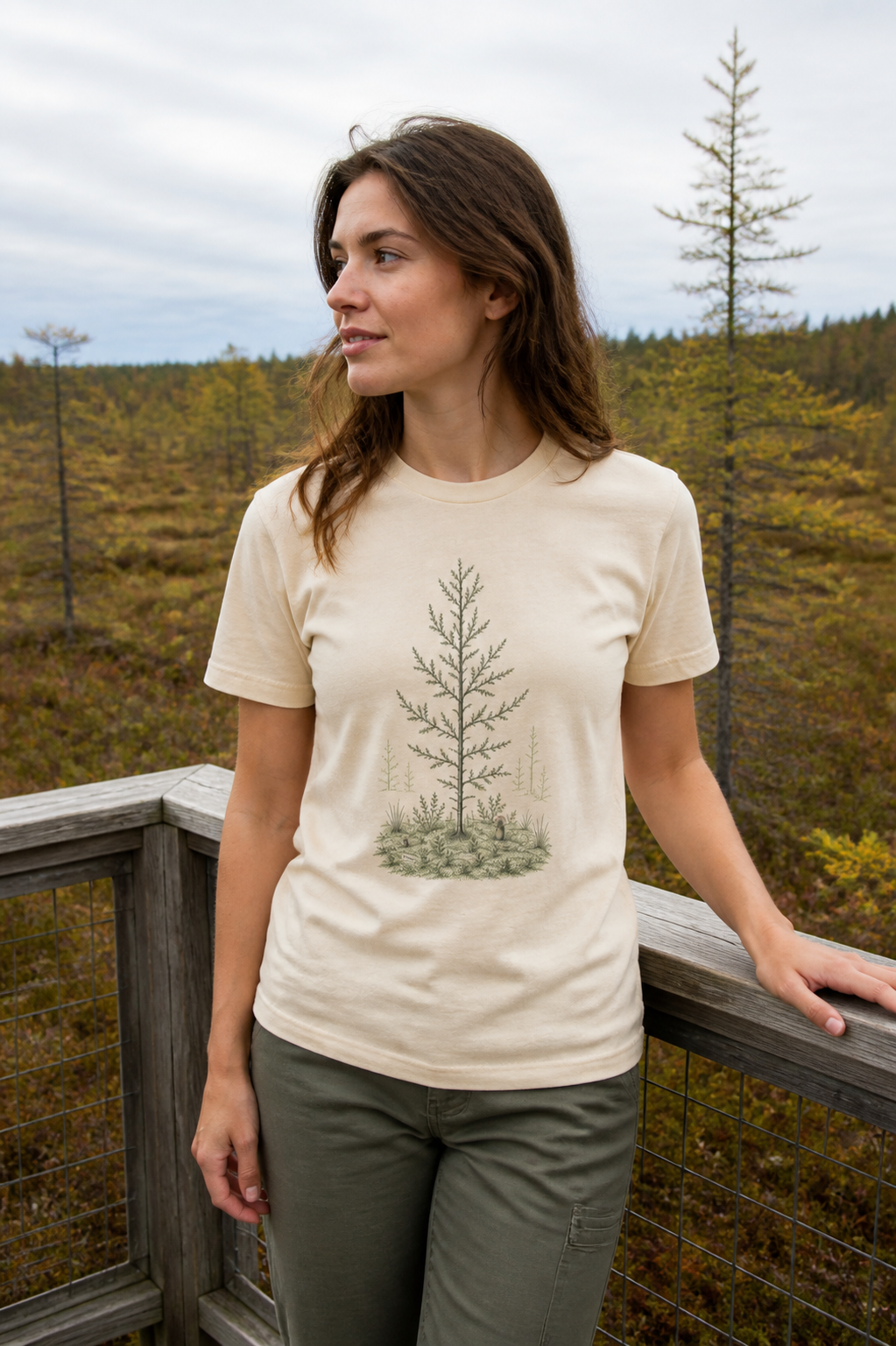 Woman wearing the Solid Natural Next Level 3600 Tamarack Bog T-Shirt at a northern bog observation platform
